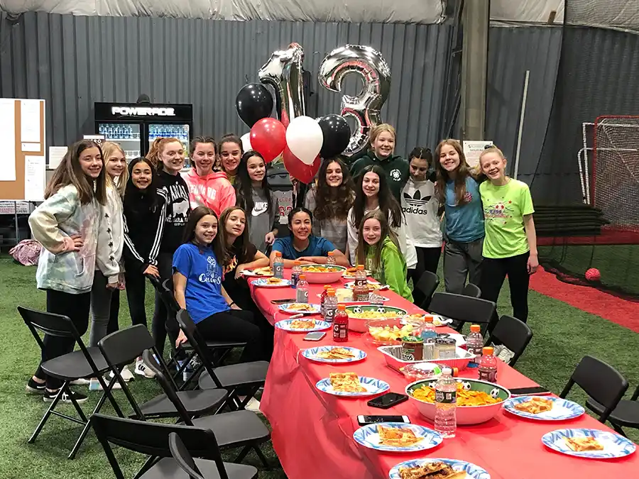 A birthday party group playing games on the turf